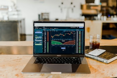 An image that showcases a trader sitting at a desk, diligently analyzing stock charts and data while maintaining a calm and focused expression, emphasizing the importance of discipline and patience in prop trading